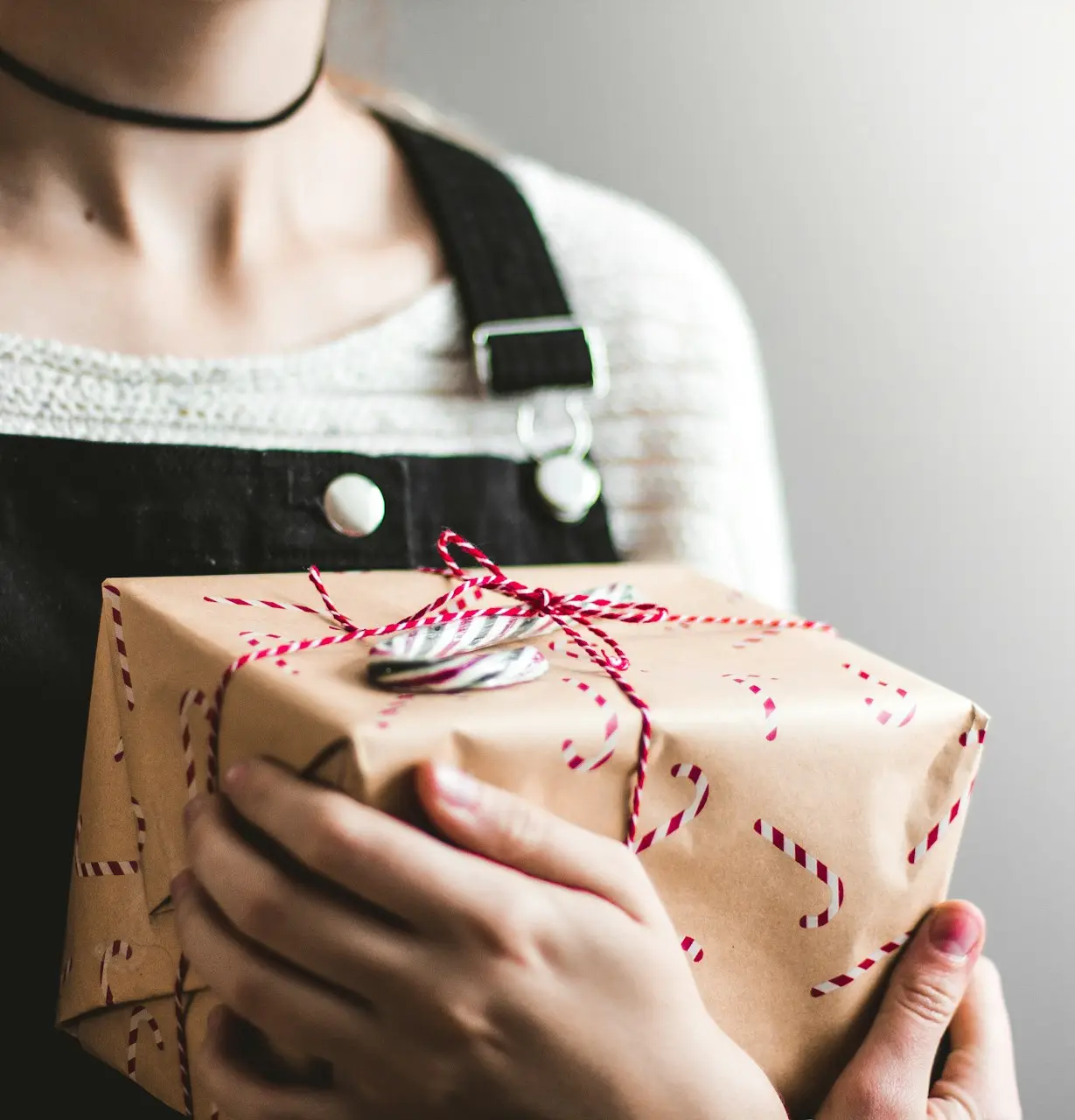 close up photography of woman holding grey and red box